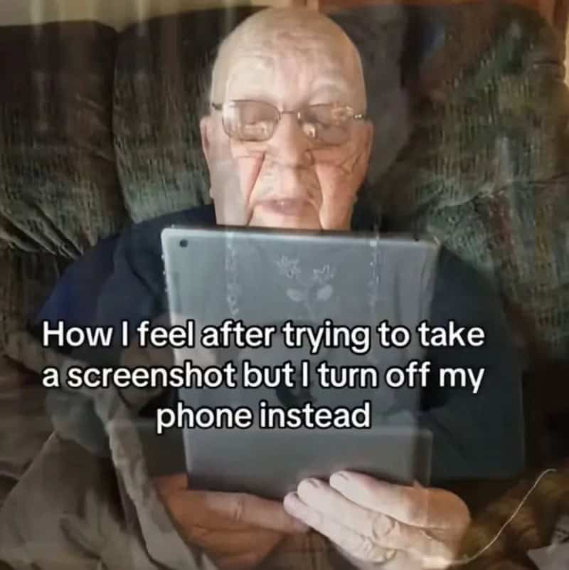 Older man with glasses looking at a tablet, feeling frustrated after trying to take a screenshot.