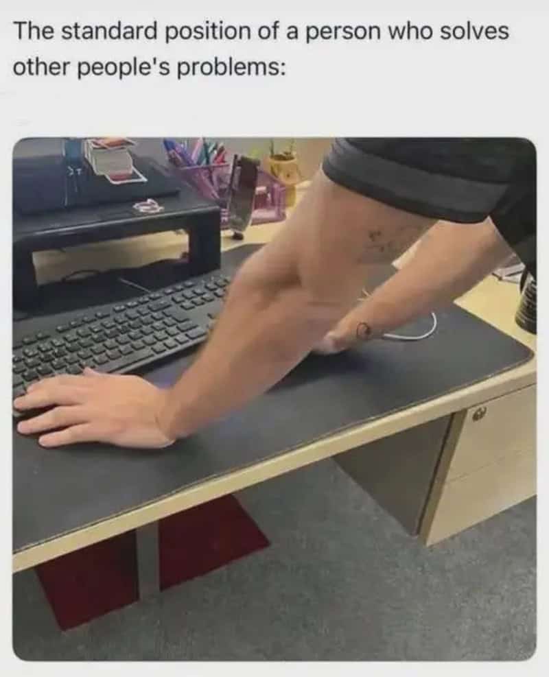 Person with tattooed arm leaning on a desk, solving problems.