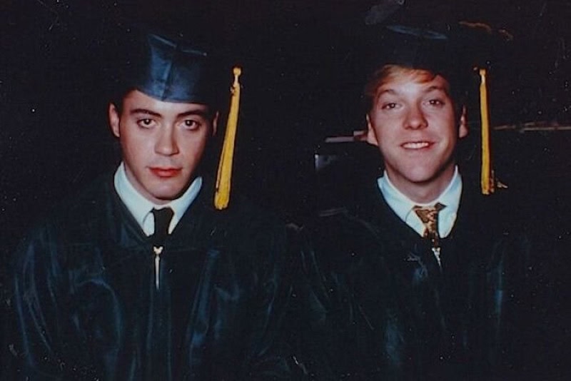 Two young men in graduation caps and gowns smiling at the camera.