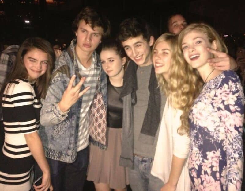 Group of young friends smiling and posing together at night.