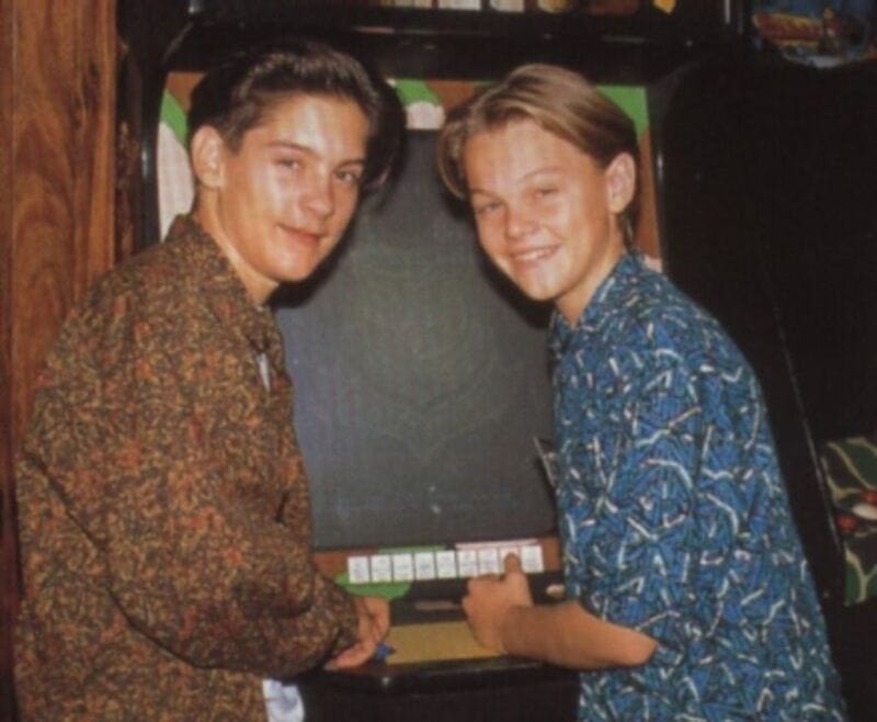 Two young boys with short hair, one in a patterned brown shirt and the other in a blue patterned top.