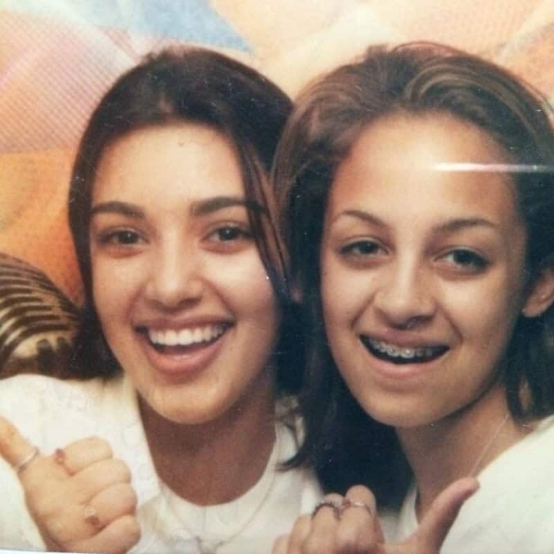 Two young women smiling and showing thumbs up, close-up photo.