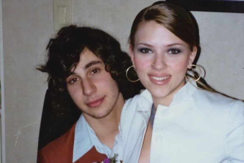 Young man and woman smiling, close together, in casual attire.