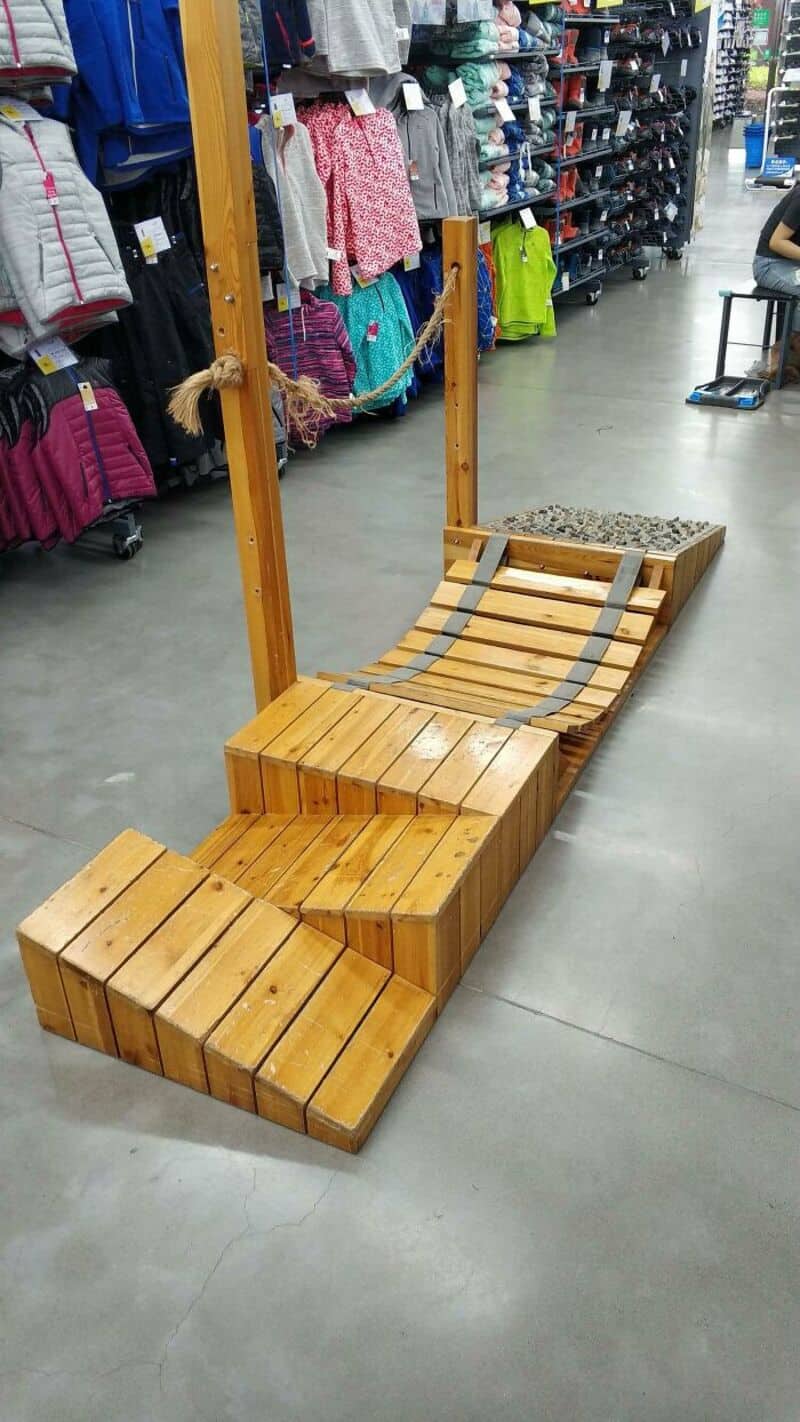 Wooden fitness equipment with steps and a sloped platform in a store.