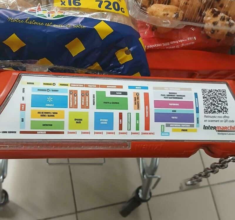 Store shopping cart with a detailed store map and snacks on top.