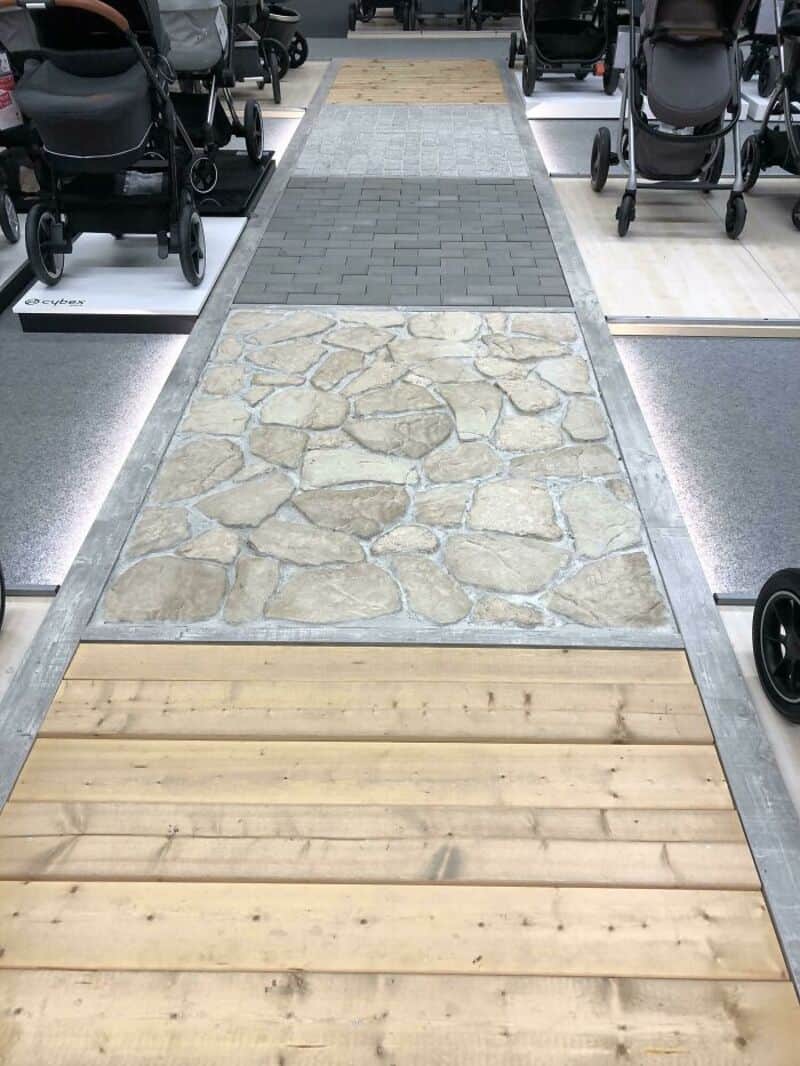 Diverse walkway with stone, wood, brick, and tile sections in a store.