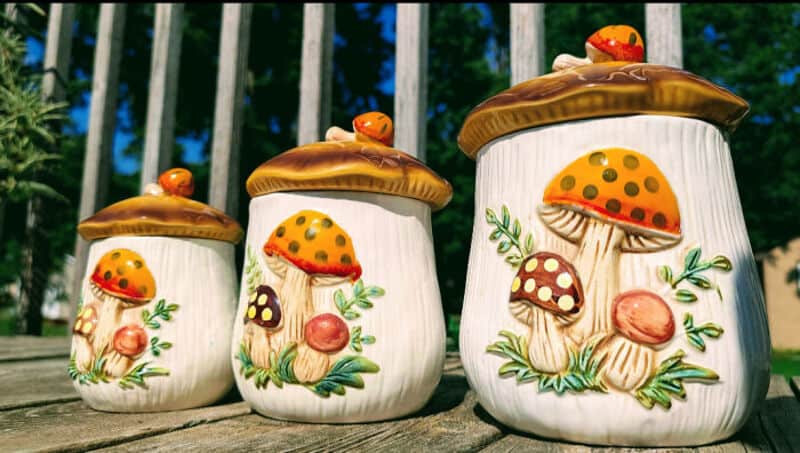 Decorative mushroom-shaped garden ornaments with ladybugs on top, set outdoors.
