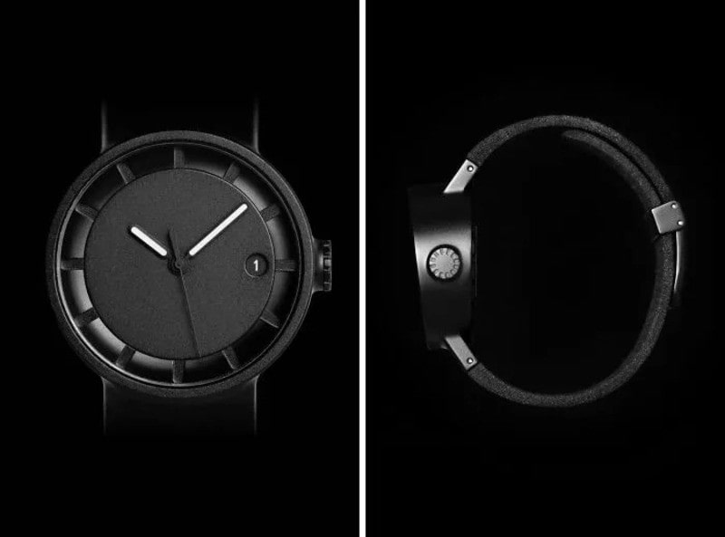 Minimalist black watch with a simple dial and leather strap.