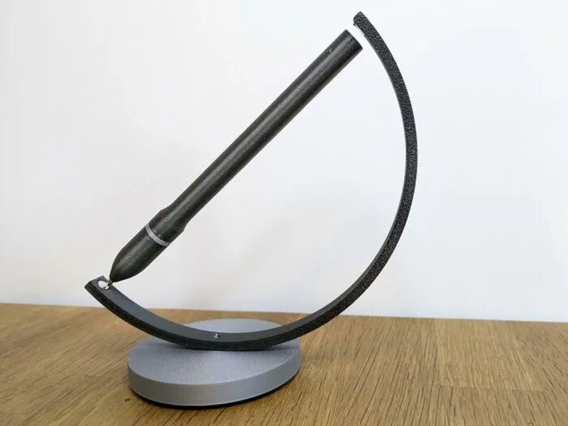 Modern black and gray desk lamp with a curved design on a wooden surface.
