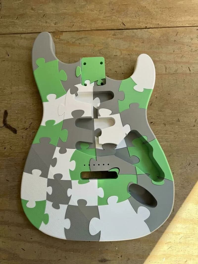 Colorful puzzle guitar-shaped 3D print model with green, white, and gray pieces.