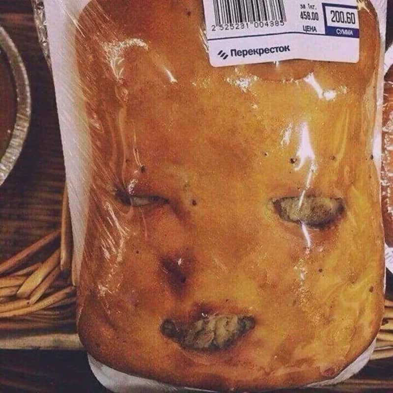 A loaf of bread with a face-like appearance, including eyes and a mouth.