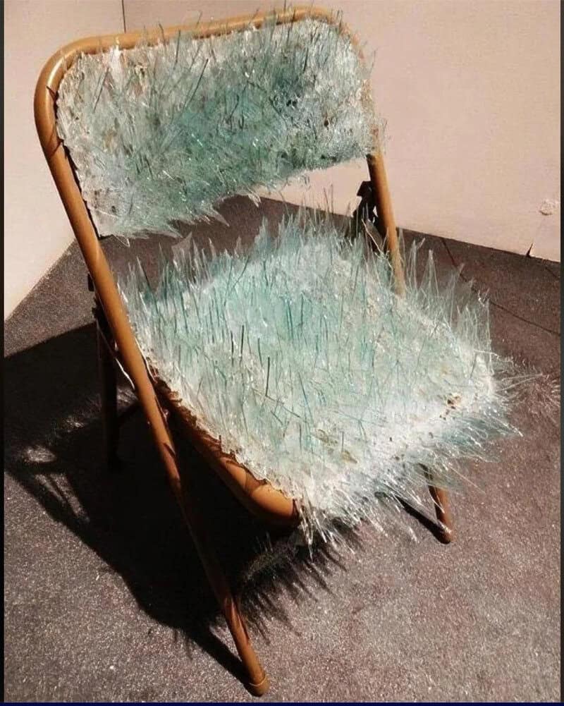 Broken glass chair with sharp shards and spikes, creepy and dangerous.