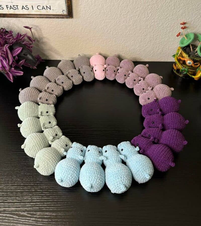 Colorful crochet bunny necklace with pastel shades on a black surface.