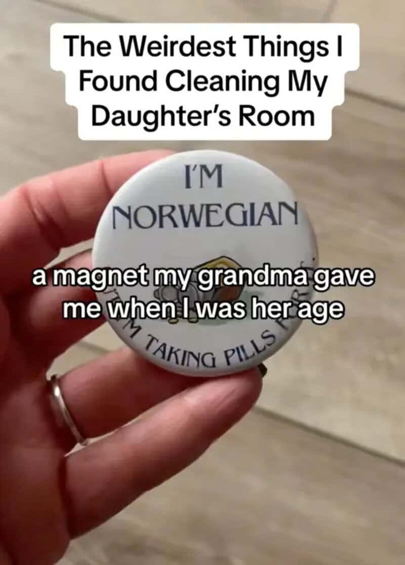 A magnet with the text 'I'M NORWEGIAN' and 'I'M TAKING PILLS' held by a hand.