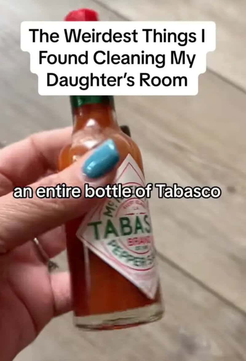 A hand holding a Tabasco sauce bottle with text about cleaning a daughter's room.
