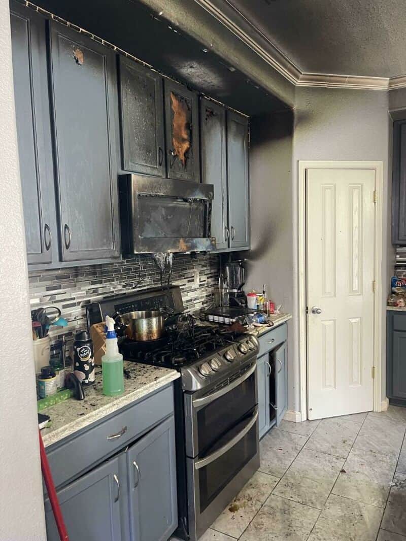 Burned kitchen cabinet above stove, kitchen with blue cabinets and stove.