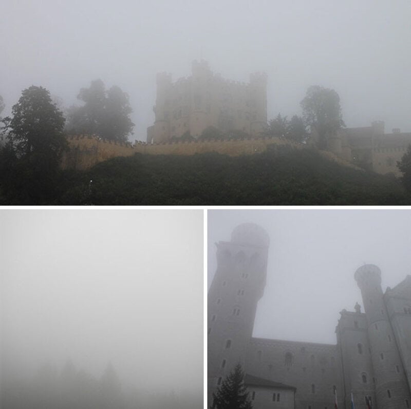 Foggy view of a castle and towers in a misty landscape.