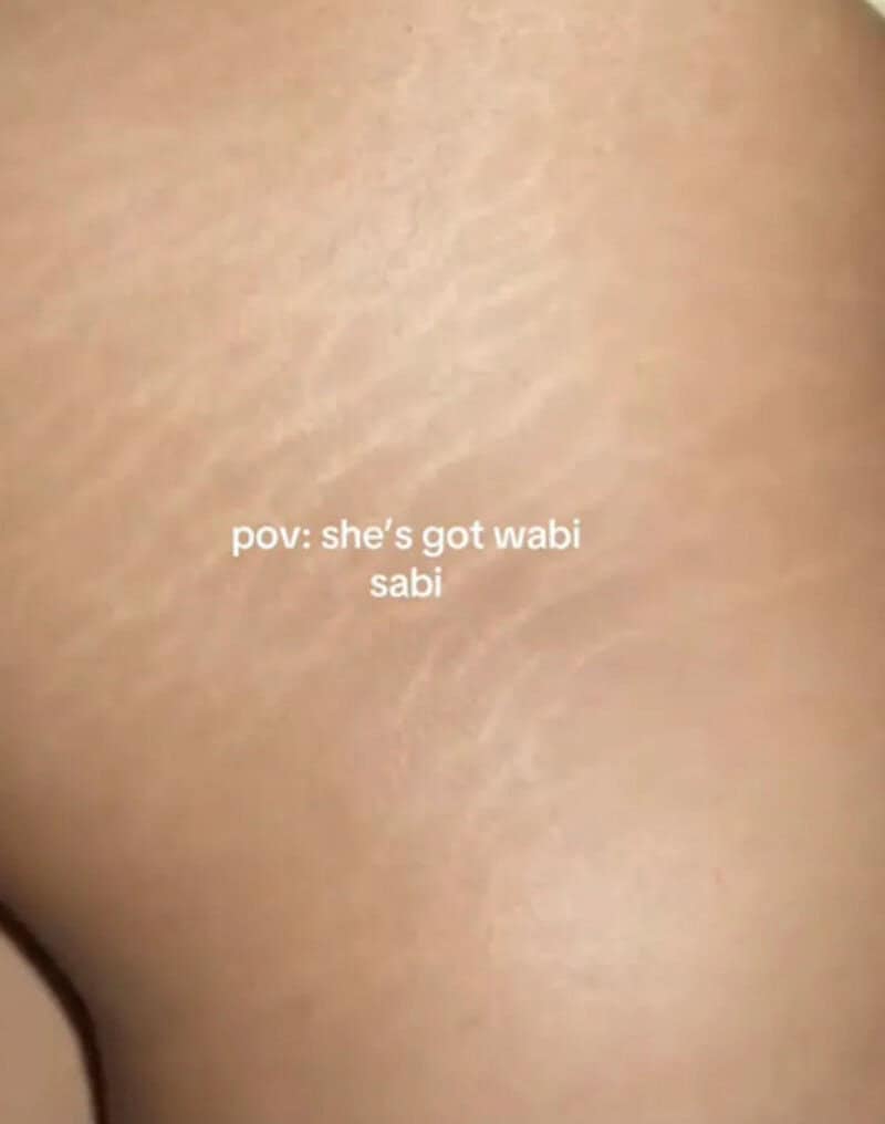 Close-up of skin with text: pov: she's got wabi sabi.