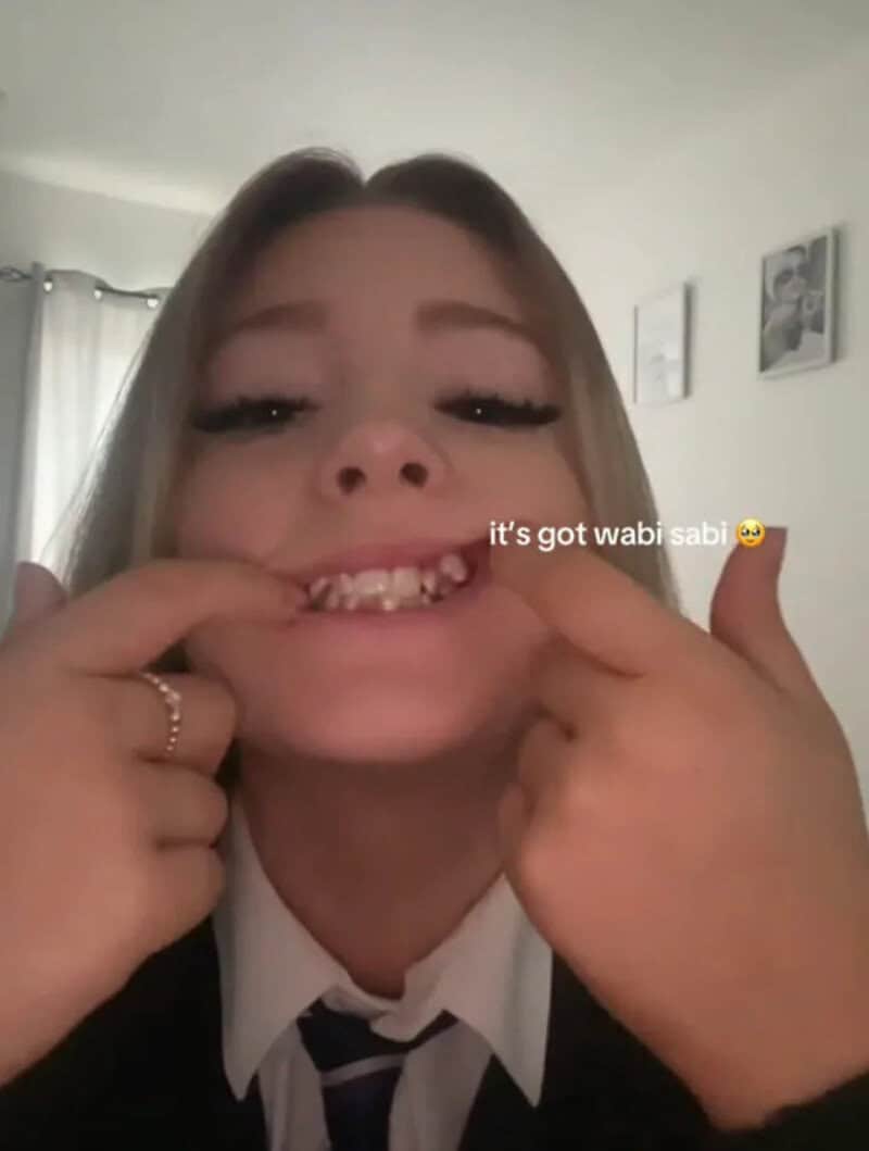 Young girl pulling her mouth wide to show her teeth, with the text "it's got wabi sabi".