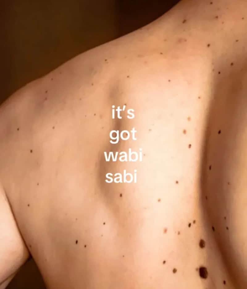 It's got wabi sabi text on a freckled shoulder skin.
