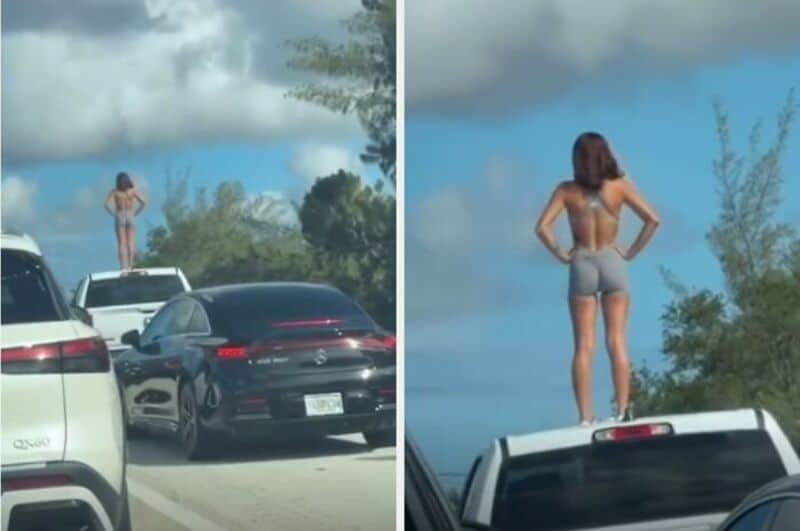 Woman standing on a car roof, looking at the sky, with cars and trees around.
