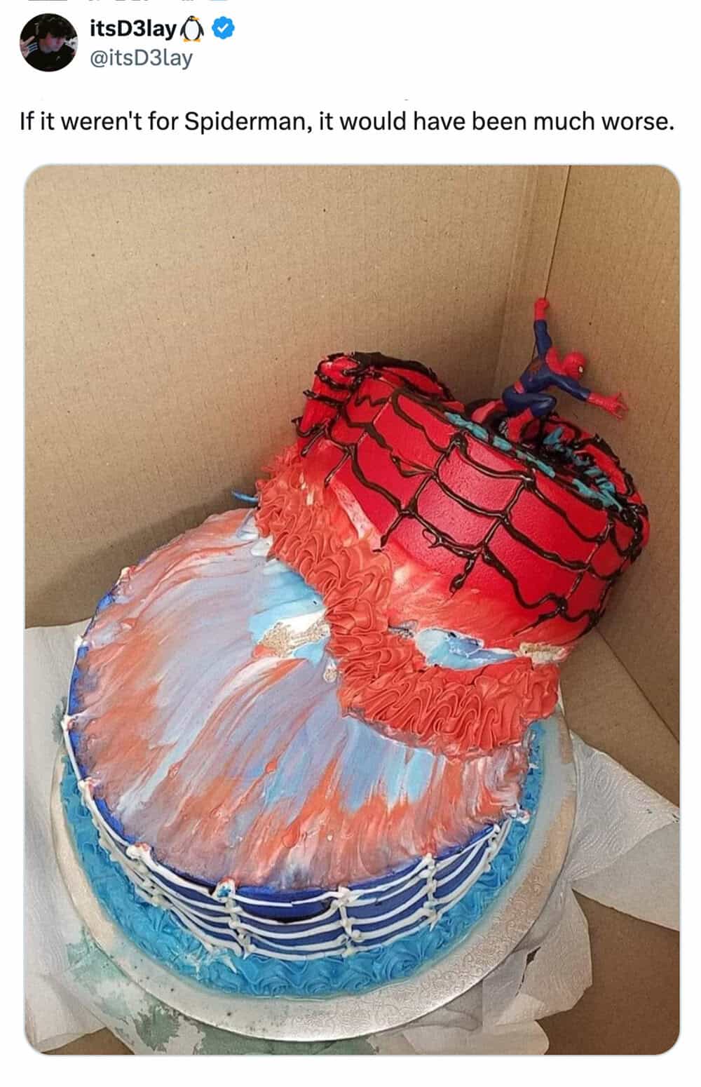 Cake decorated as Spider-Man's mask with a small Spider-Man figure on top.