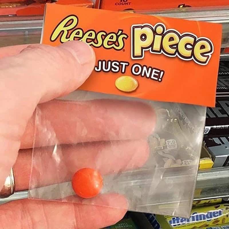 Reese's Piece candy in a clear plastic bag with a hand holding it.