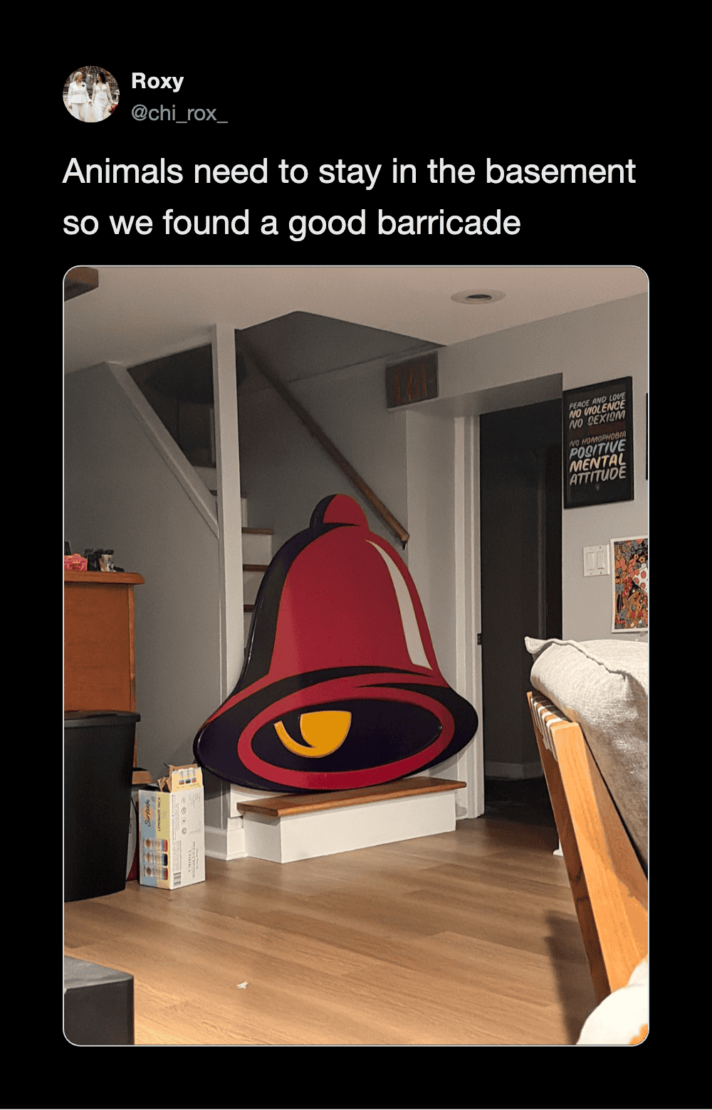 A large red bell with a yellow eye, used as a barricade in a basement.