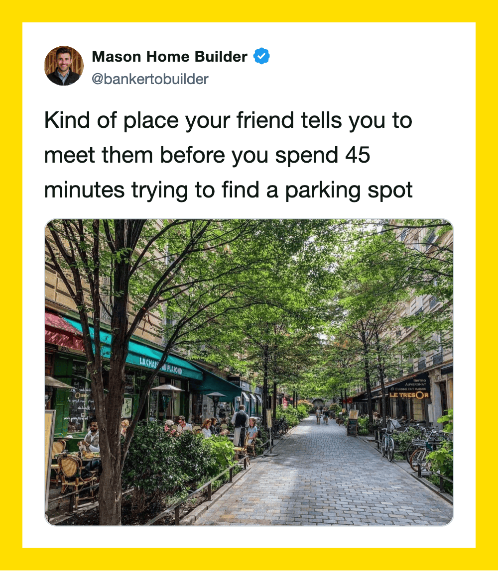 A busy outdoor cafe with many people and a parking lot in the background.