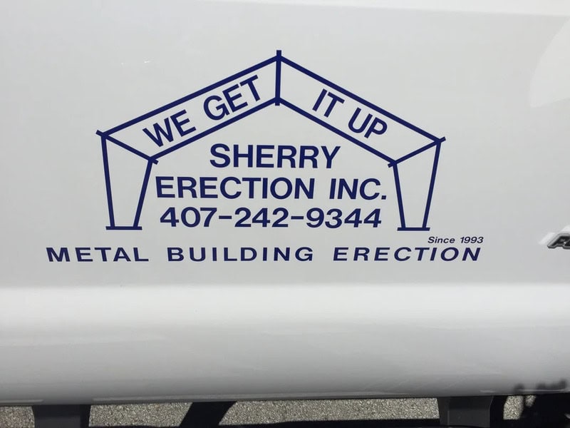 Sign reads 'We get it up, it up, Sherry Erection Inc., 407-242-9344, metal building erection'.