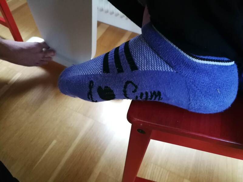 Shoe with the words "i love Cum" written on it, sitting on a red chair.
