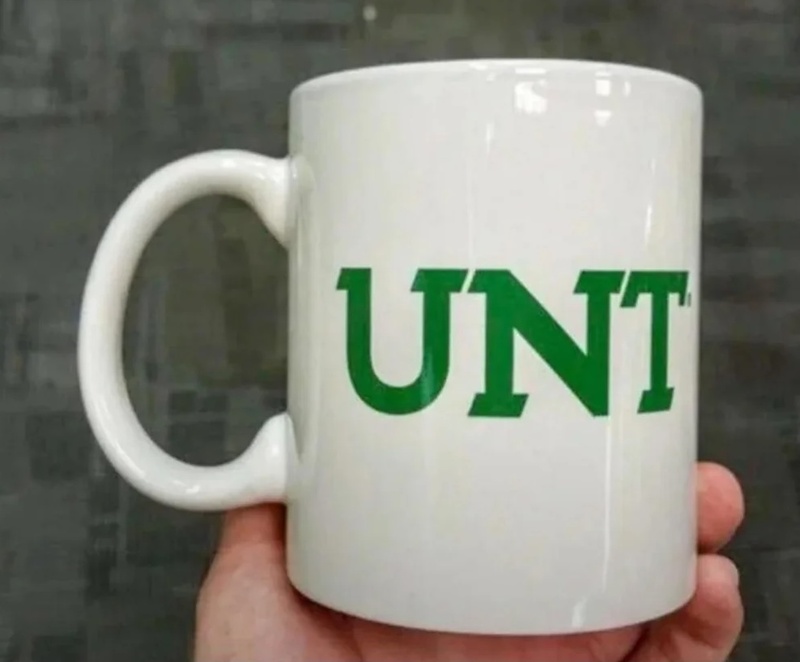 Mug with the word 'UNT' printed on it, held in a person's hand.