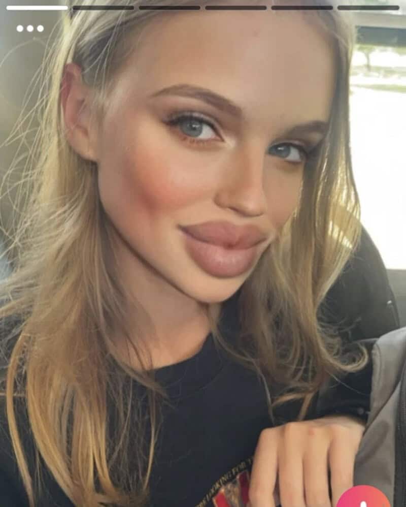 Close-up of a young woman with blonde hair and blue eyes smiling.
