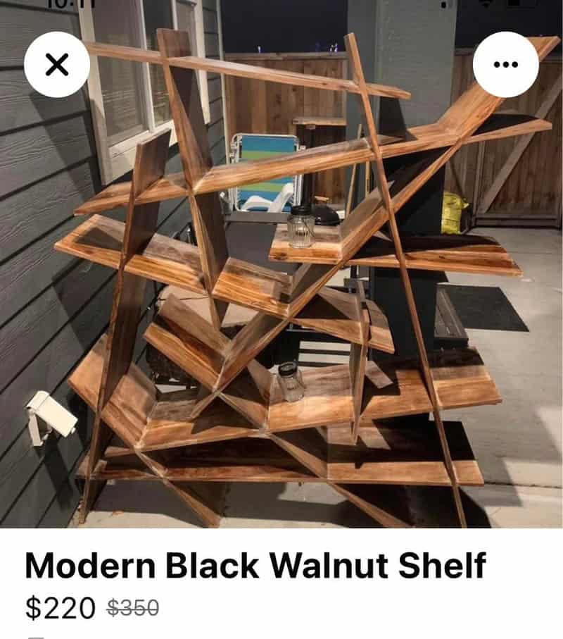 Modern black walnut shelf with an abstract, angular design on a porch.