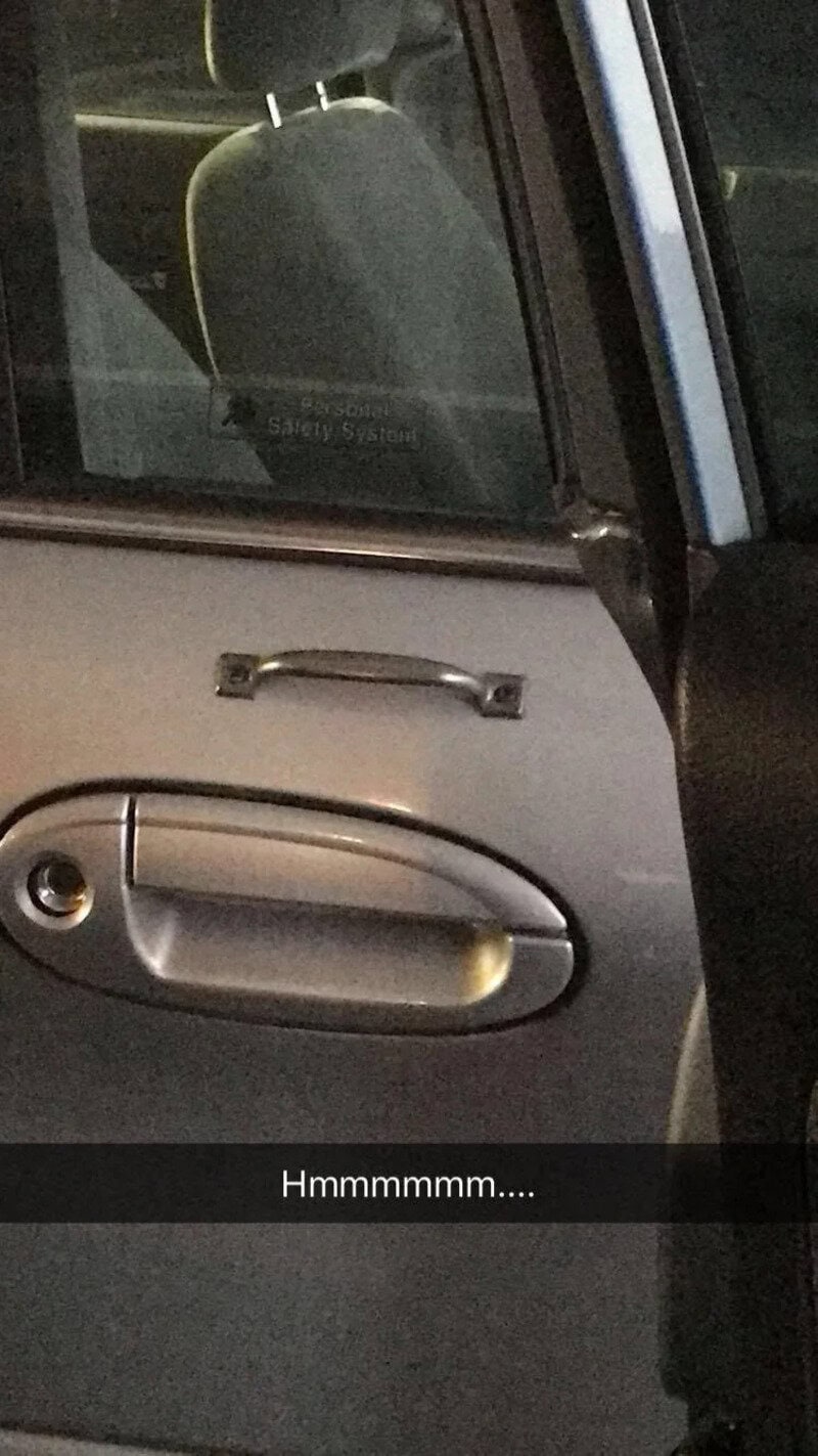 Car door with a handle and a window, reflection shows part of the interior.