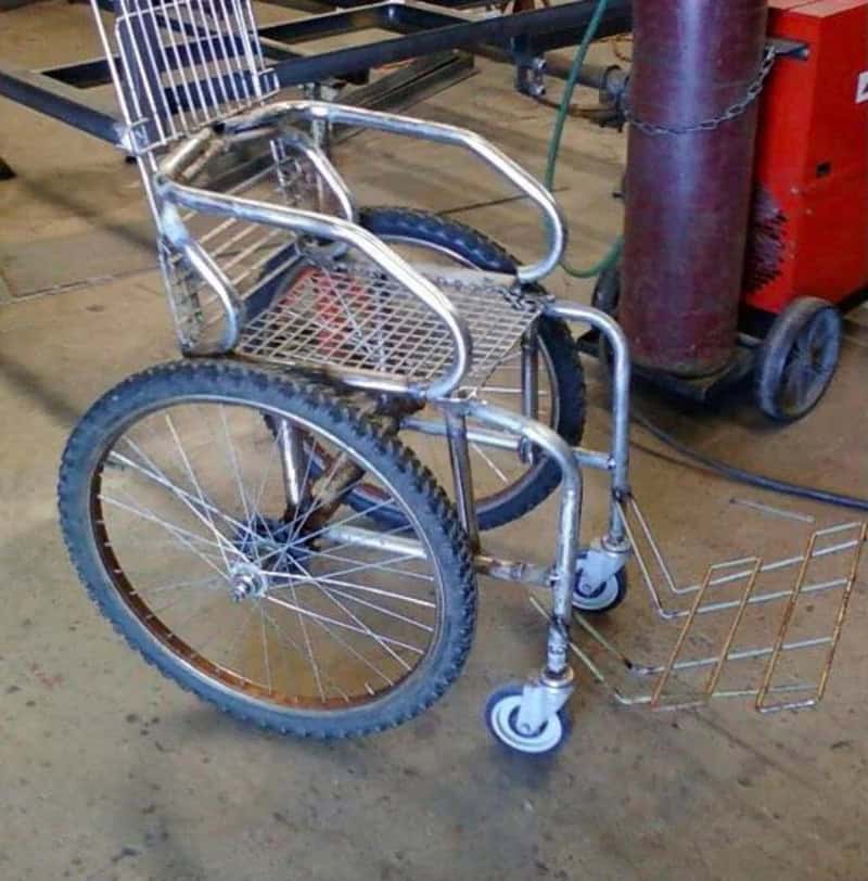 Modified wheelchair with a shopping cart basket and a small front wheel.