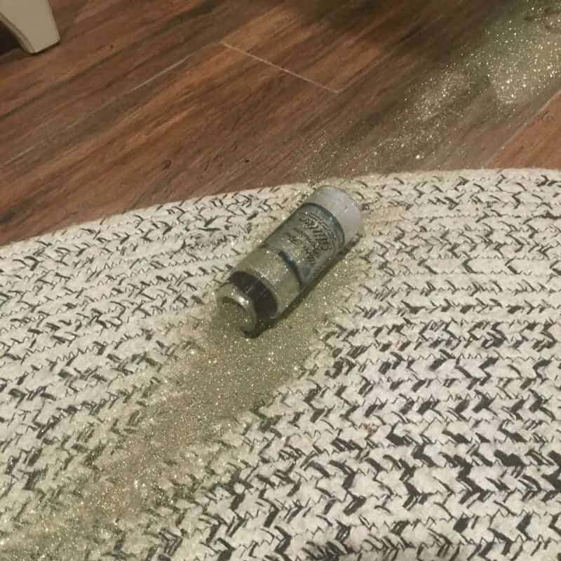 Salt shaker spilled on a woven rug, with salt scattered on the floor.