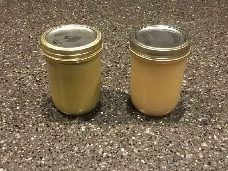 Two jars with different colored contents on a speckled countertop.
