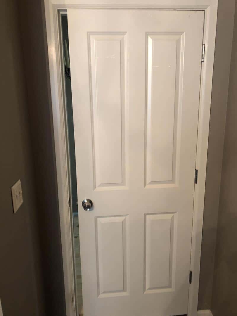 White door with a doorknob and a small gap at the bottom.