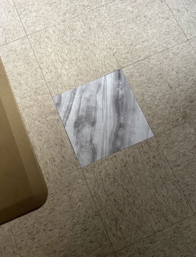 A tile on the floor is missing, revealing a different patterned tile underneath.