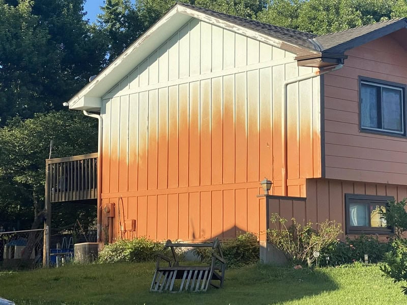 House with orange paint streaks on the side wall, part of a home improvement fail.