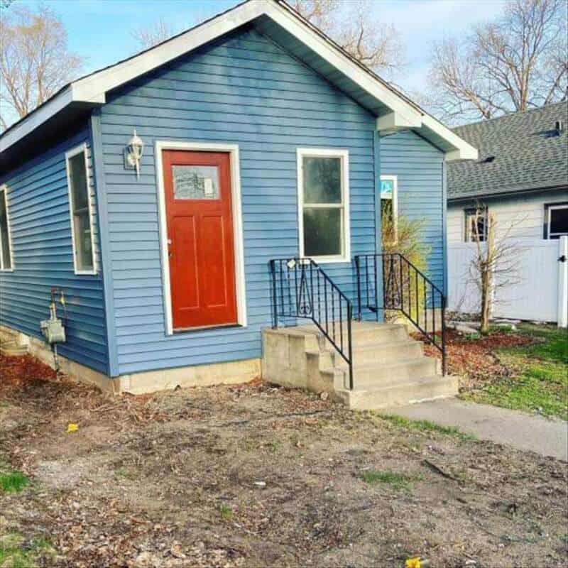 Blue house with a red door and concrete steps, part of 'funny-home-improvement-fails' post.