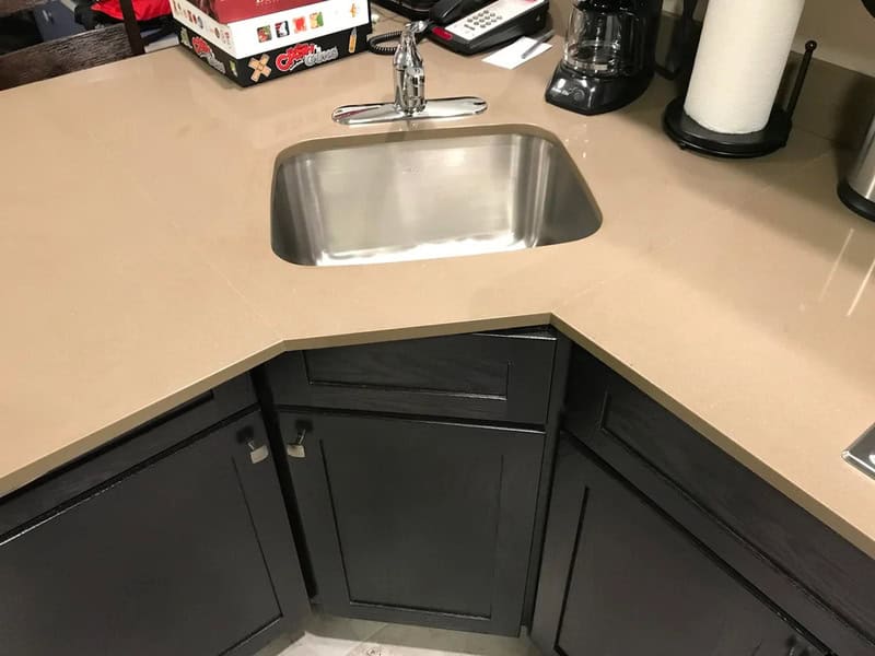 Kitchen corner with sink, coffee maker, and paper towel holder.