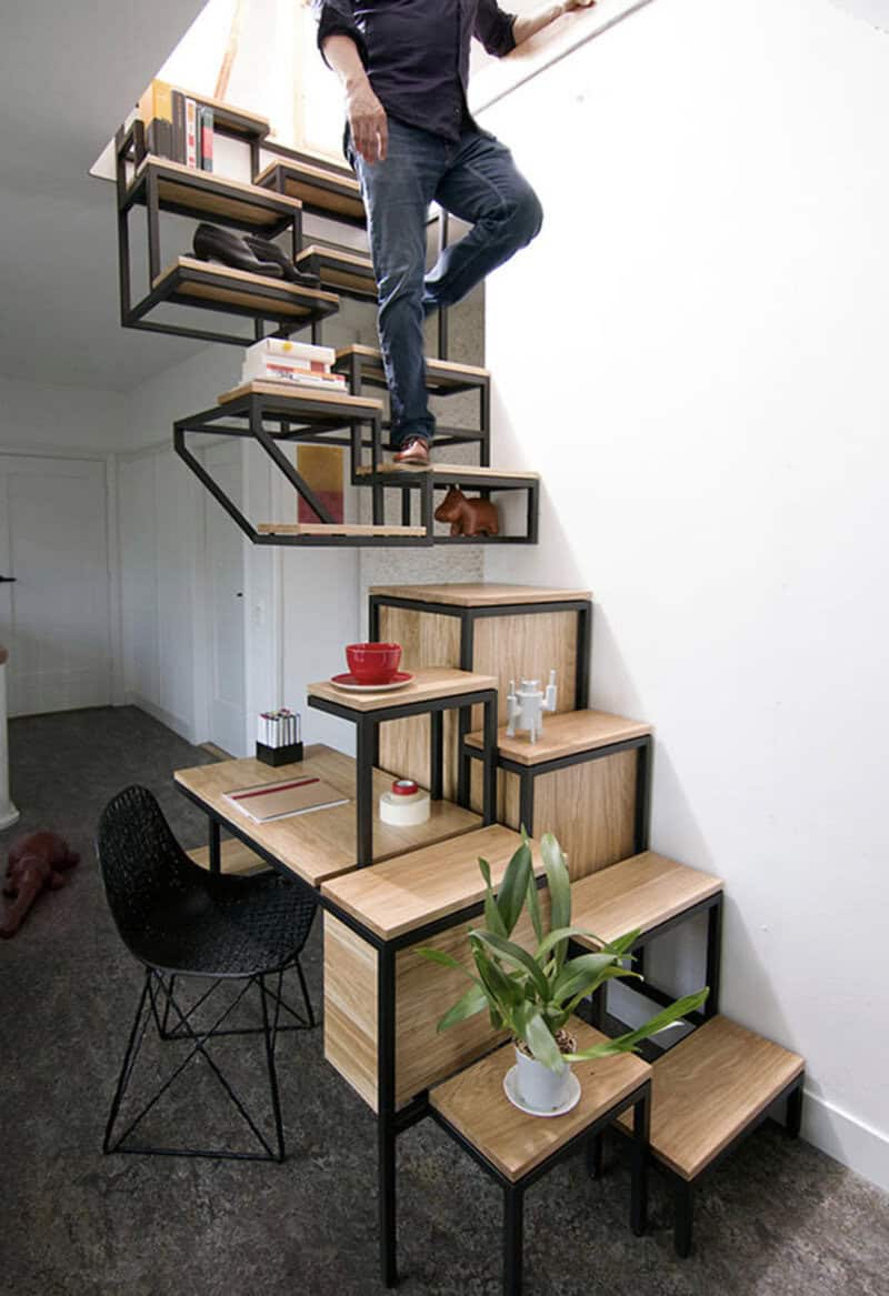 Person standing on a staircase with books and a dog on the steps.