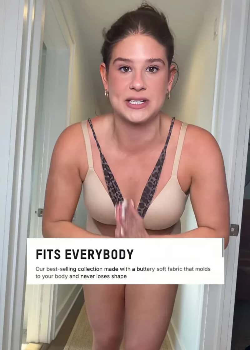 Influencer in beige SKIMS outfit with hands together, testing fit.