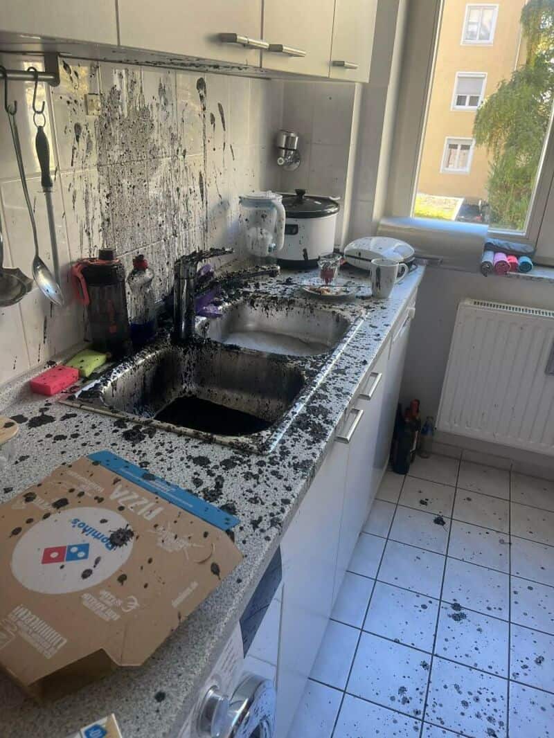 Burnt and blackened kitchen sink and countertop after a fire or explosion.