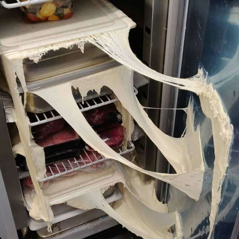 Broken fridge door with melted ice cream spilling out.