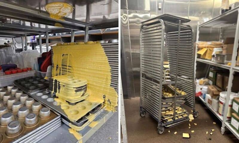 Stacked yellow trays and spilled pasta on a kitchen cart in a commercial kitchen.