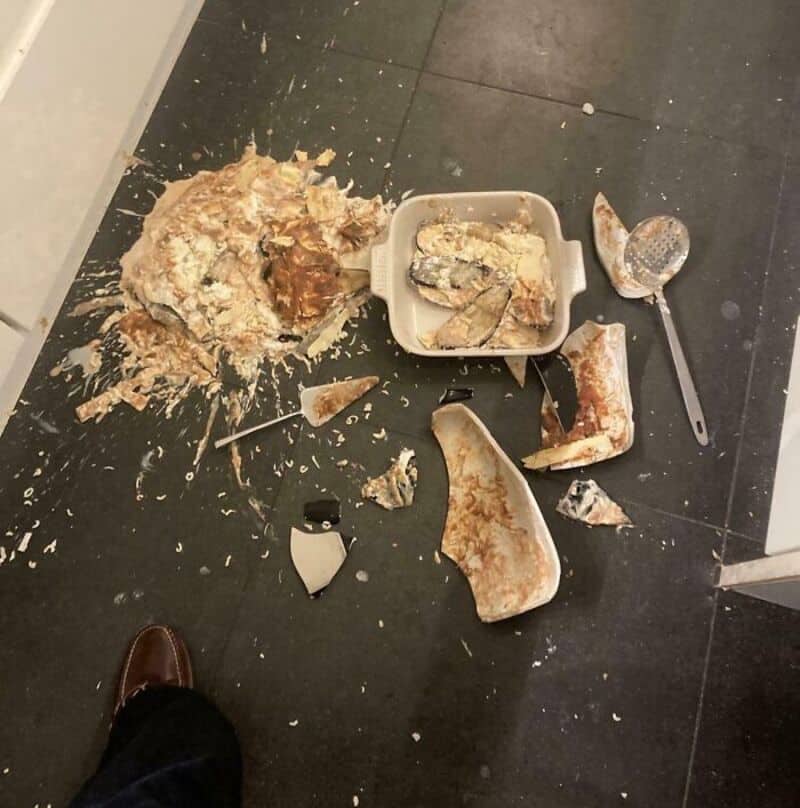 Messy kitchen floor with broken dishes and food debris, possibly from a failed cooking attempt.