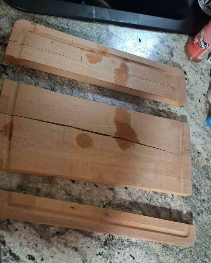 Three wooden planks with water stains on a kitchen countertop.